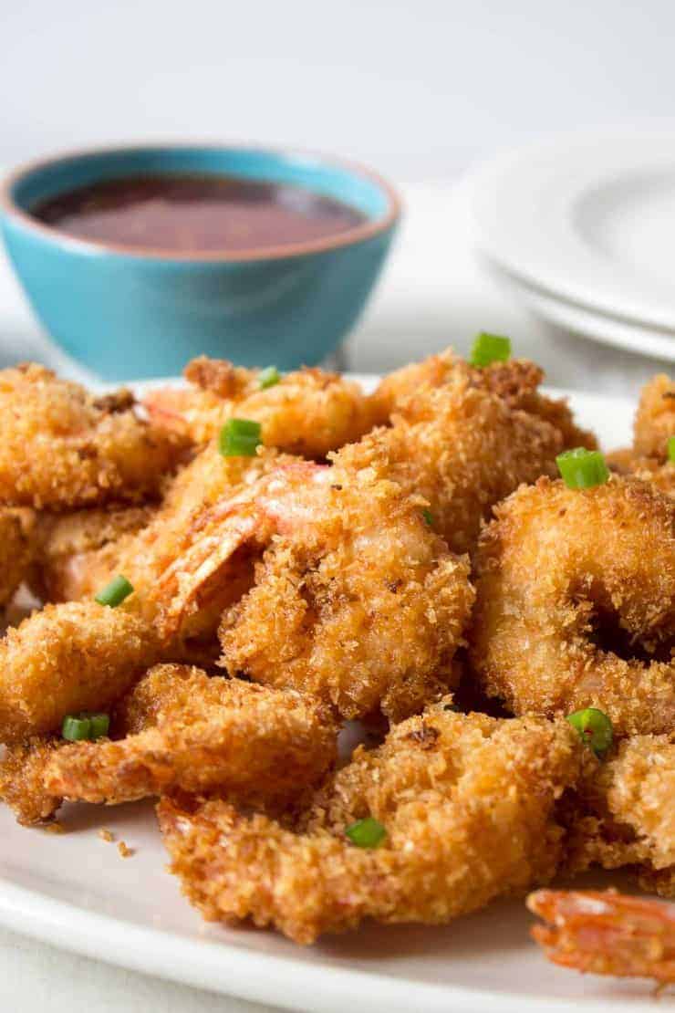 Coconut shrimp piled on a white platter.