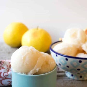 A small blue bowl filled with scoops of grapefruit sorbet.