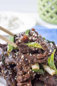 Strips of cooked meat topped with sesame seeds and chopped green onions.