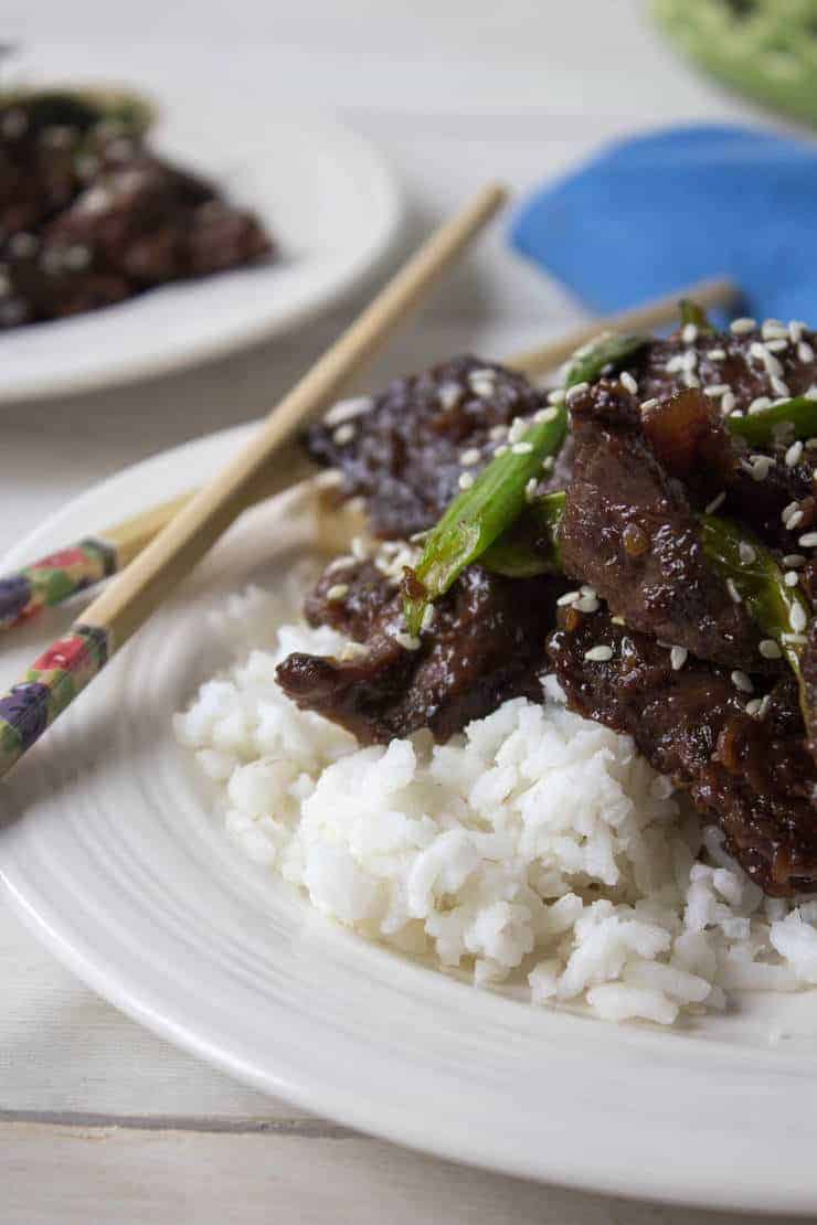 Mongolian Beef served over a bed of rice and topped with sesame seeds.