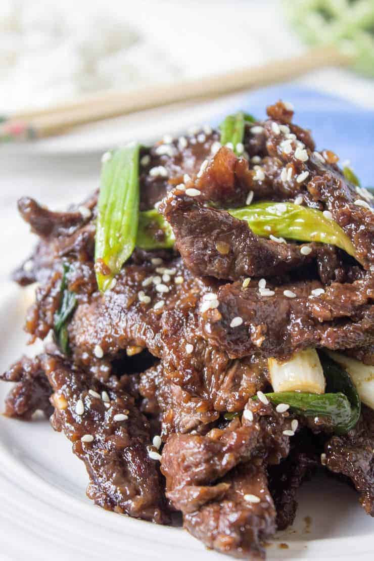 A plateful of Chinese food topped with green onions.
