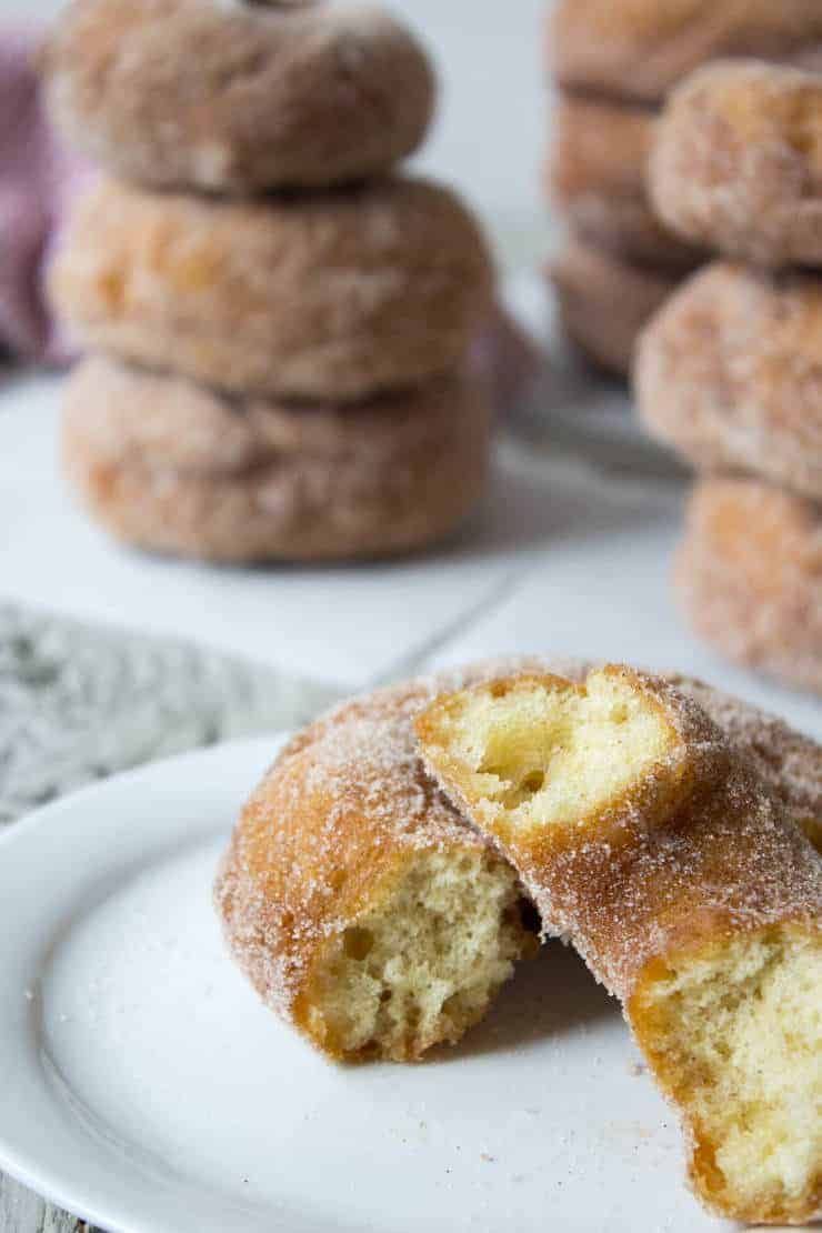 A donut split in half on a white plate. 