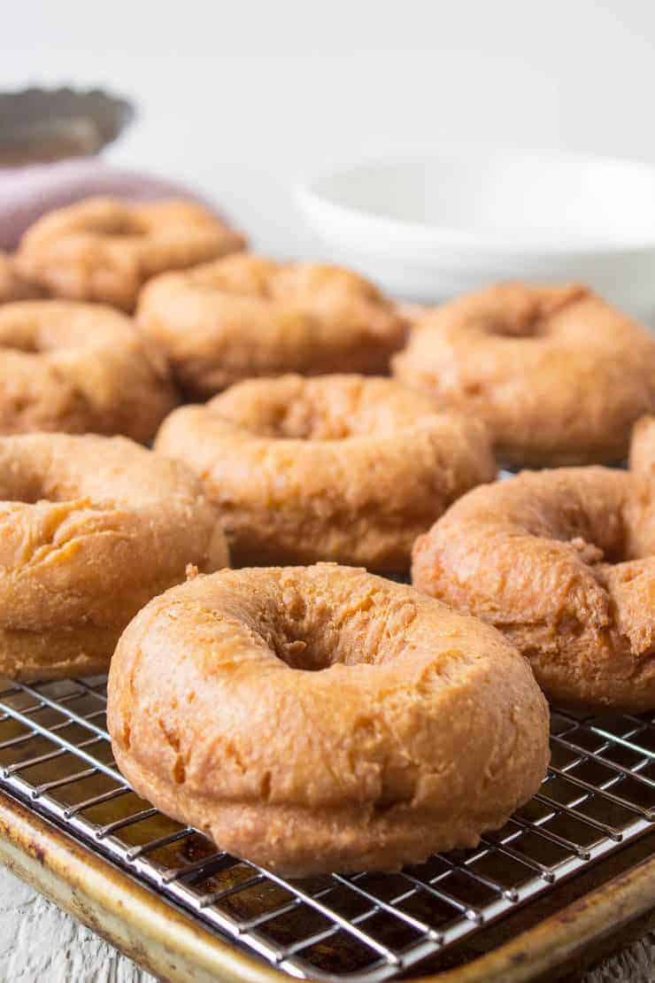 Doughnuts cooling on a baking rack.