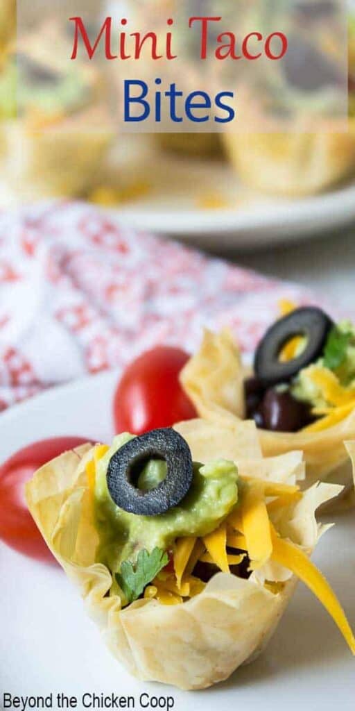 A mini taco cup topped with a sliced black olive.