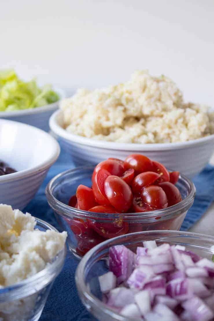 Red onions, tomatoes, and rice in small bowls. 