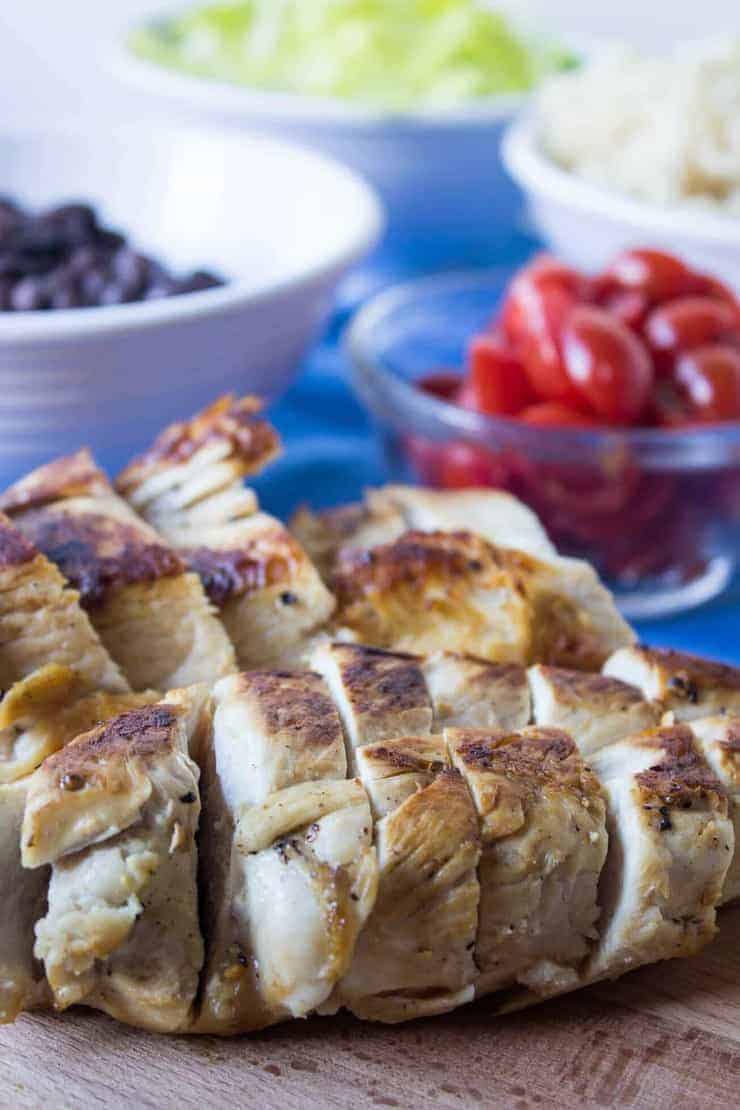 Chicken cooked and sliced on a cutting board. 