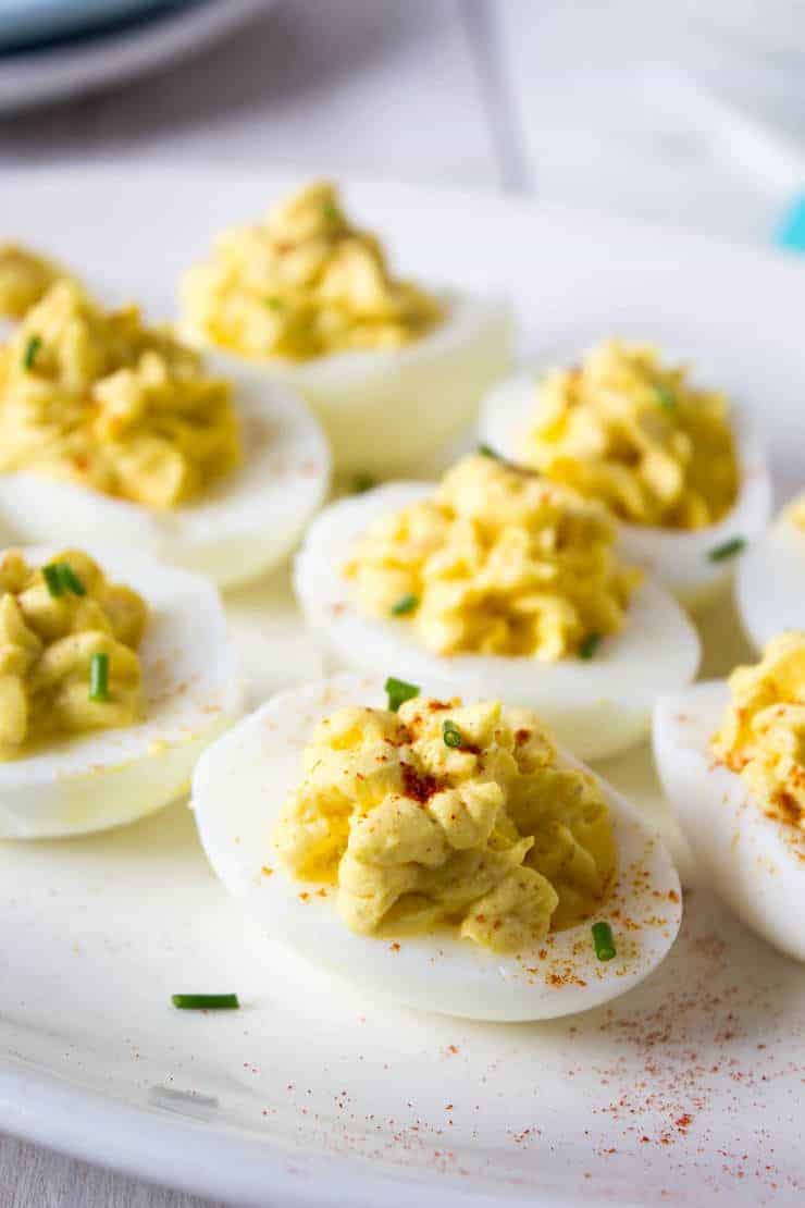 Classic deviled eggs sprinkled with paprika and chives.