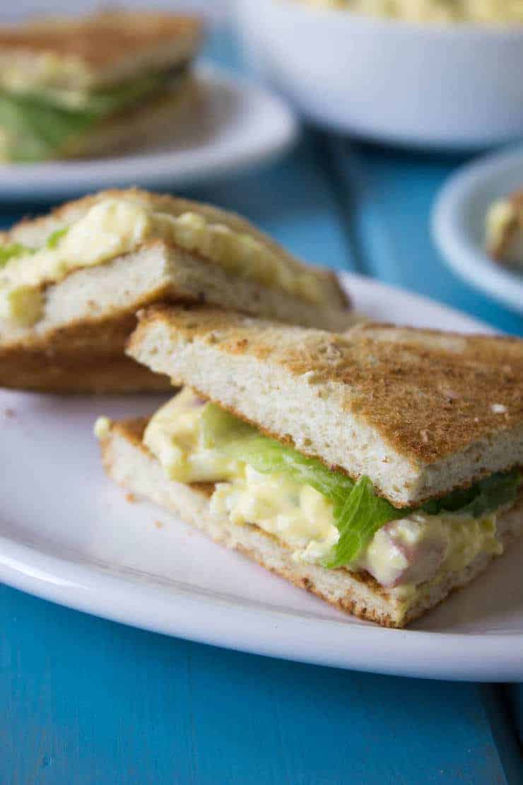 Small sandwiches filled with egg salad and lettuce.