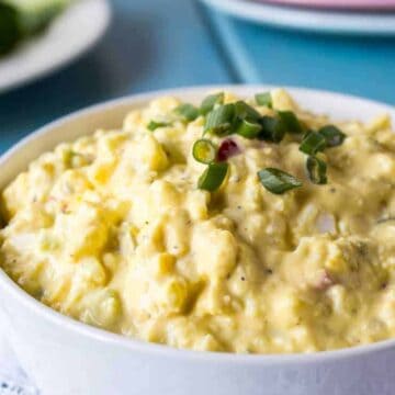 A white bowl filled with yellow egg salad.