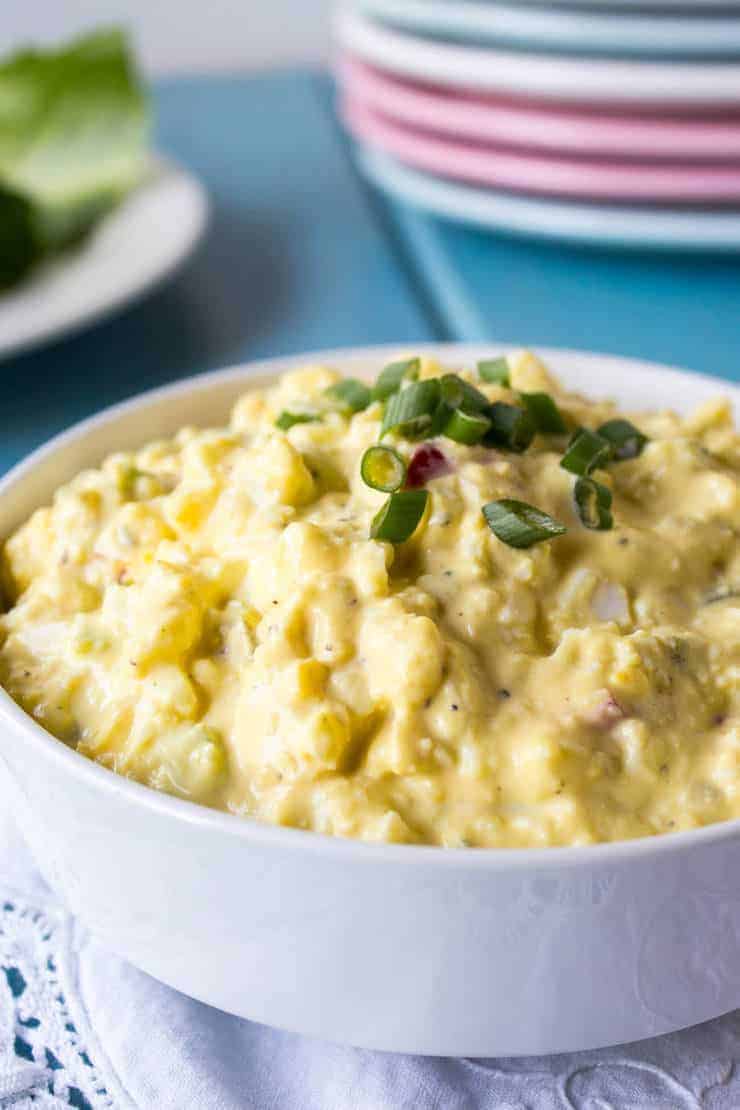 A white bowl filled with yellow egg salad.