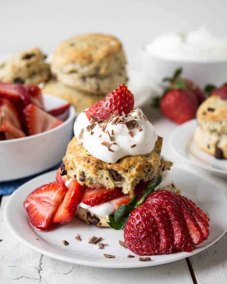 A strawberry shortcake stacked with fresh strawberries and chocolate shavings.