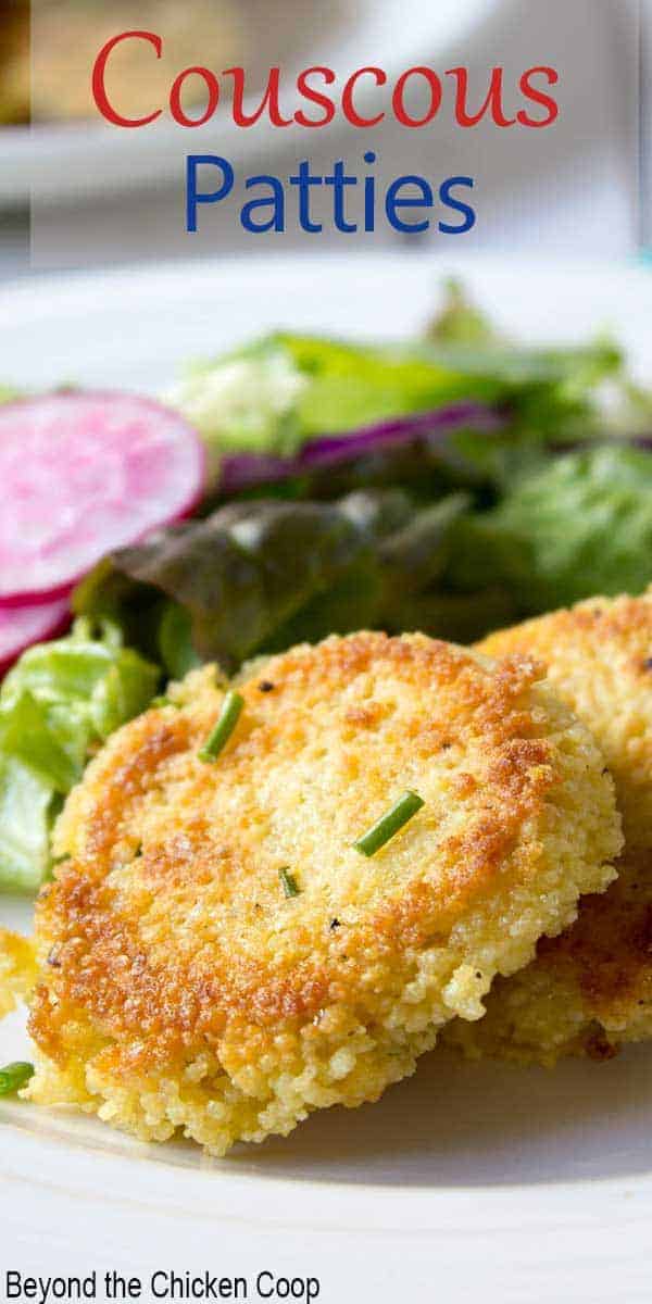 Couscous patties on a plate next to a green salad.