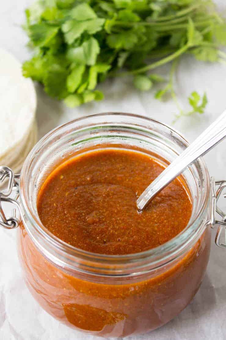 Homemade enchilada sauce stored in a glass jar.