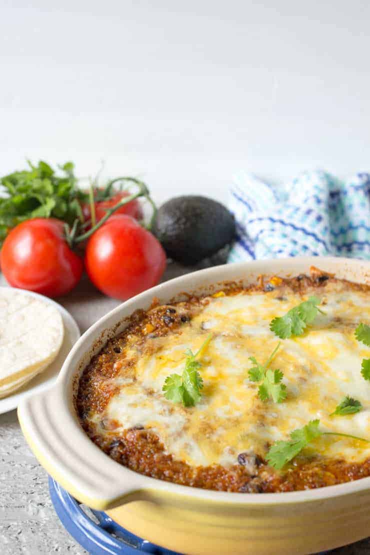 Quinoa Enchilada Bake served in a casserole dish topped with cheese. 
