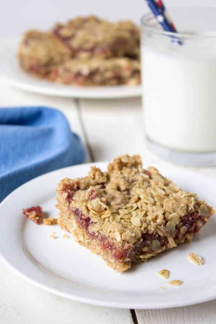 Raspberry oat bars served with a glass of milk.