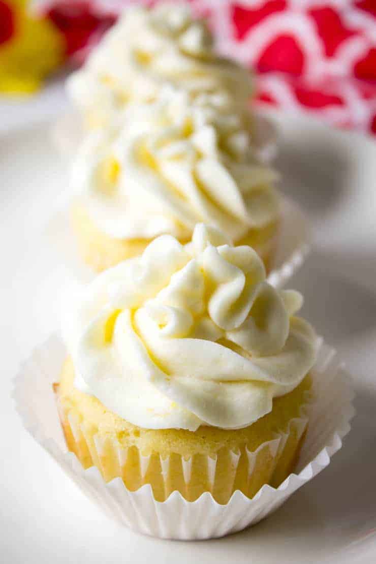 A platter filled with lemon cupcakes topped with frosting.