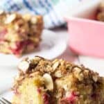A slice of coffee cake filled with raspberries and topped with almonds.