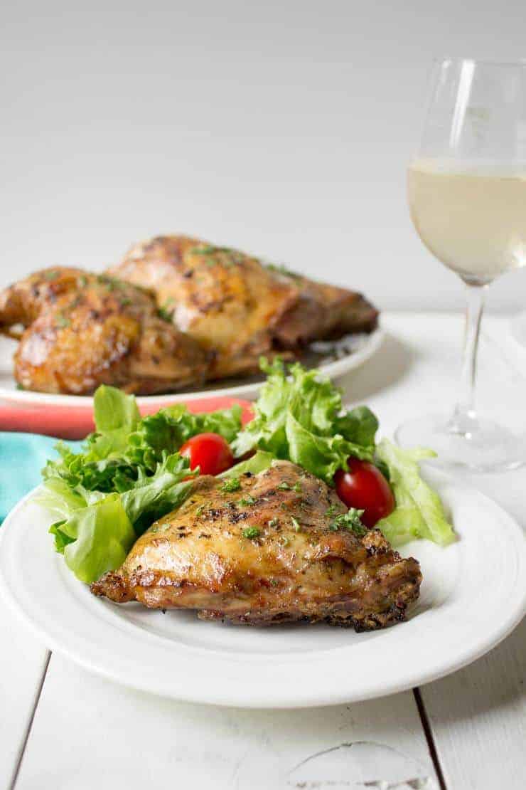 A dinner table set with grilled chicken and a green salad. 