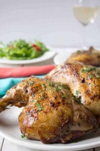 Grilled chicken pieces on a white plate.