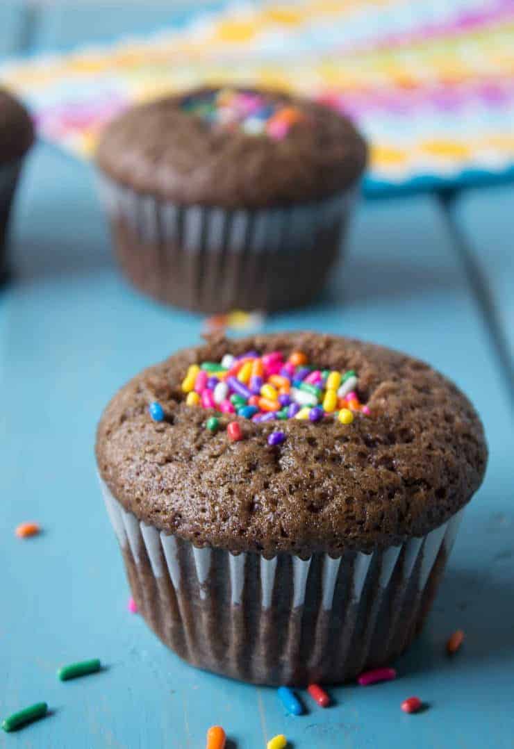 A chocolate cupcake filled with colored sprinkles. 