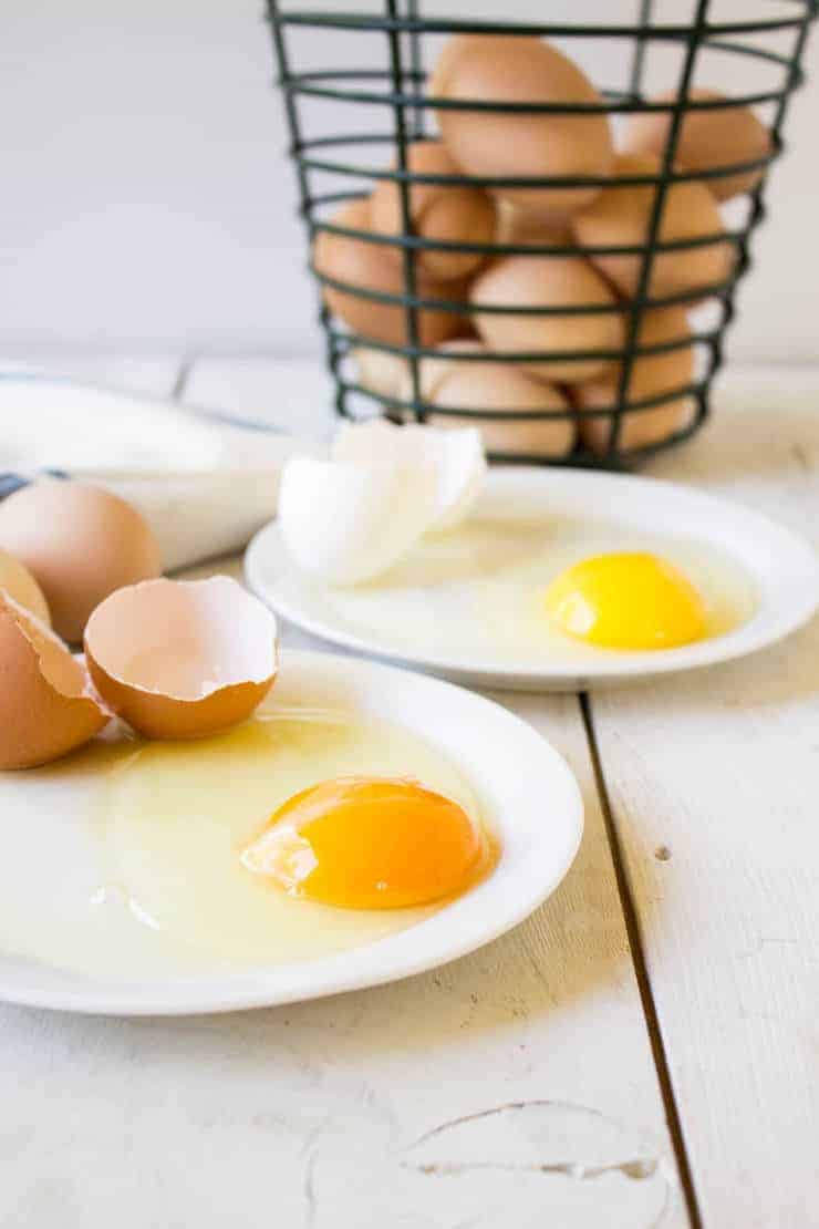 Uncooked eggs on a plate.