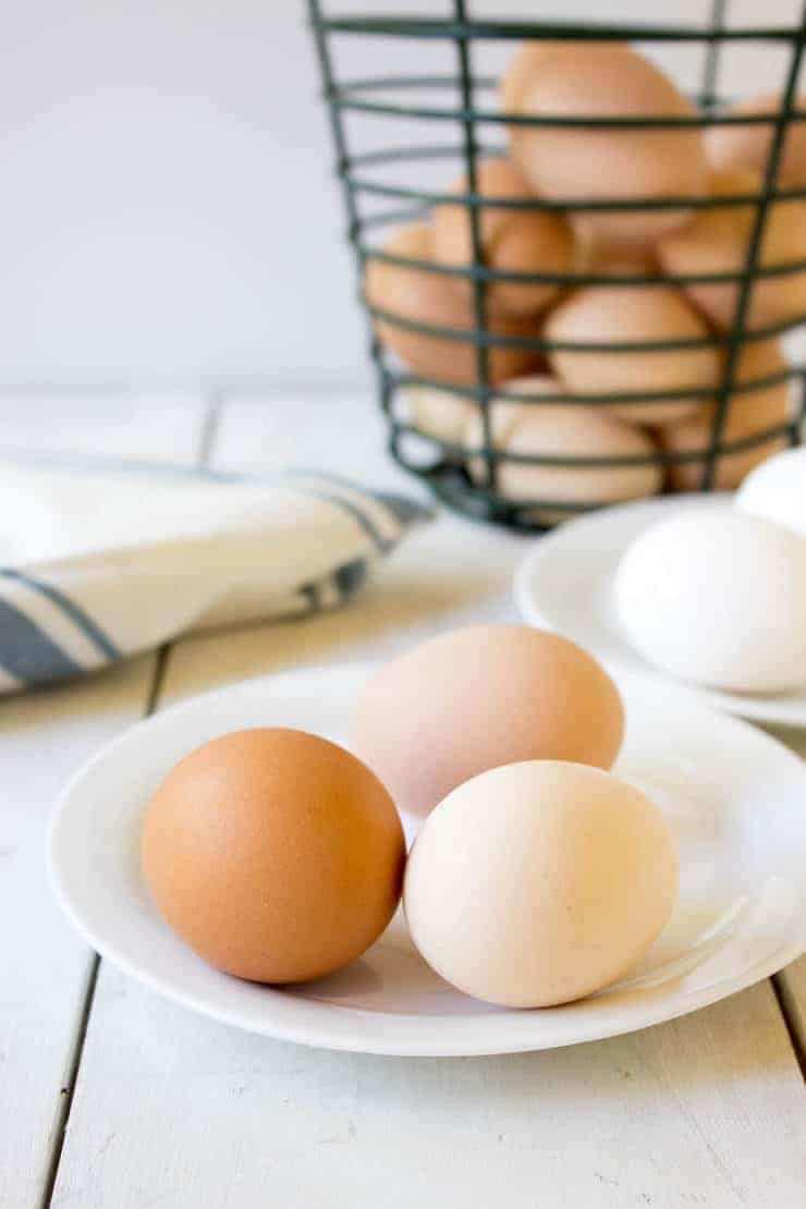 Farm fresh eggs on a small white plate.