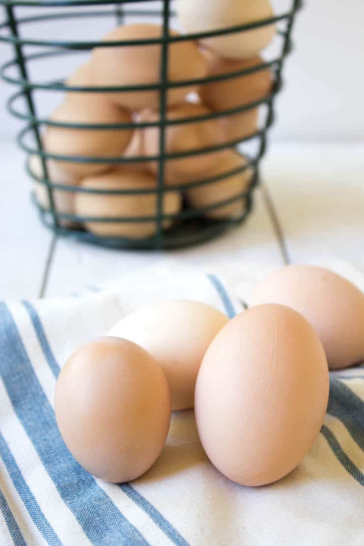 Different colored eggs on a stiped napkin.