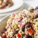 A white bowl filled with a whole grain salad.