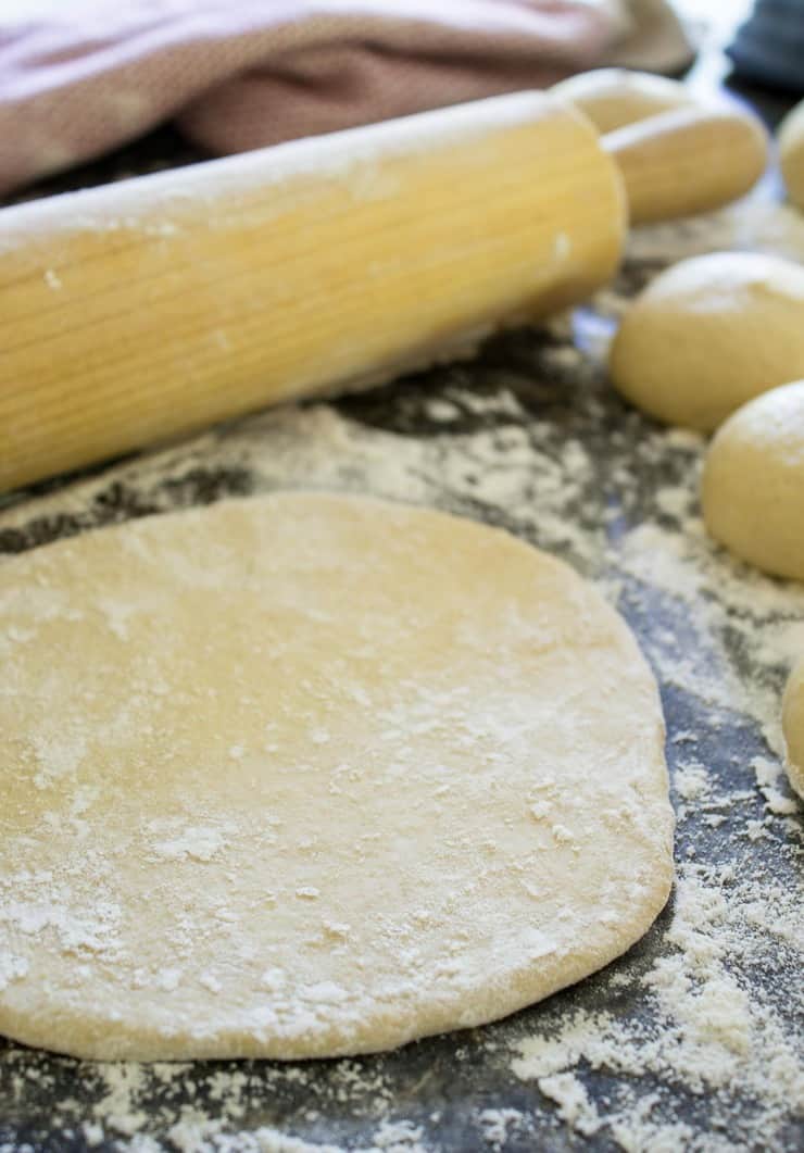 Rolling out disc of bread dough. 