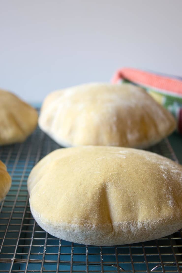 Homemade Pita Bread fresh out of the oven and resting on a baking rack. 