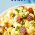 A bowl filled with corn and bits of bacon.