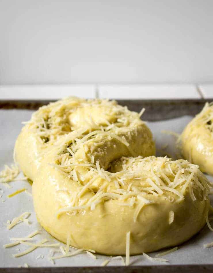 Loaves of bread dough topped with Parmesan cheese.