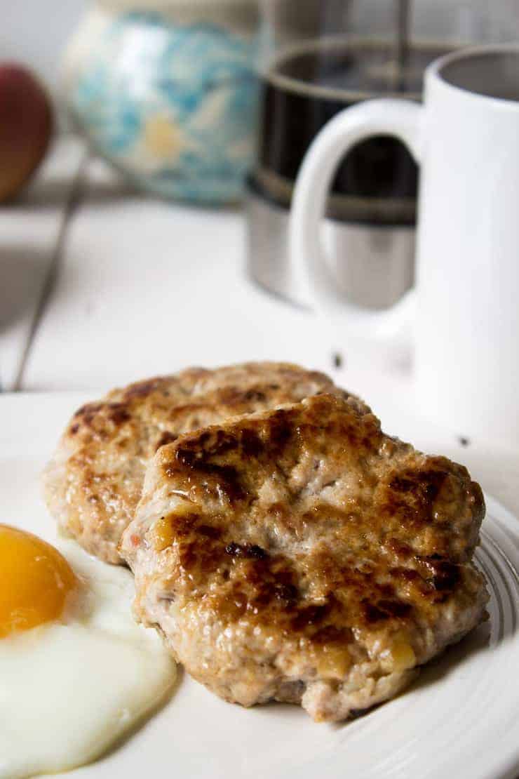 Two round sausage patties on a small plate. 