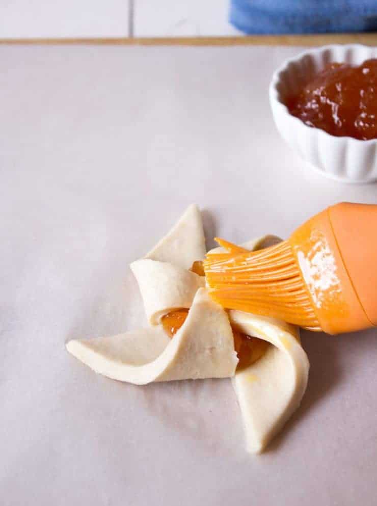 Egg wash being brushed on a pastry.