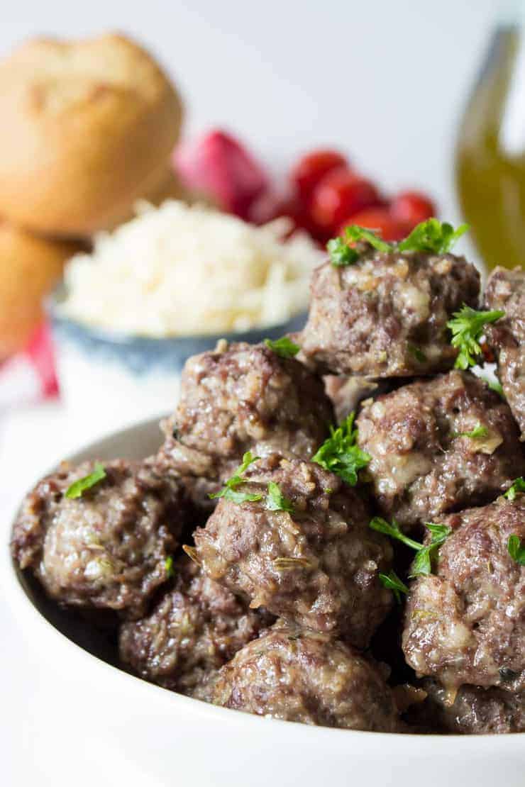 Meatballs topped with fresh green herbs.