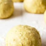 Bread dough formed into round balls on a floured board.