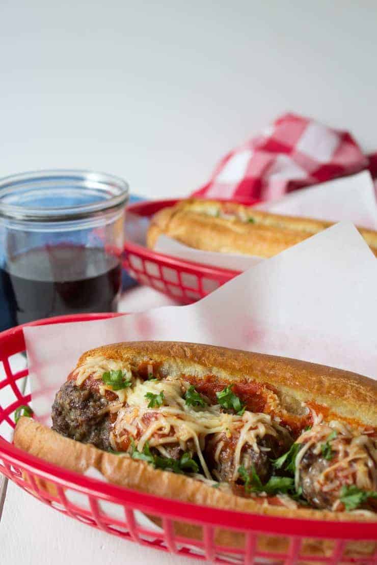 Italian meatball sub sandwiches in a red basket.