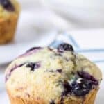 A blueberry muffin with blueberry juice dripping down the sides of the muffin.