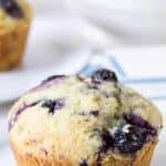 A blueberry muffin with blueberry juice dripping down the sides of the muffin.