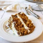 A slice of carrot cake on a white plate.