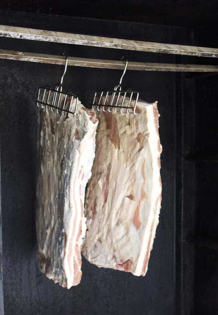 Fresh bacon being placed into the smoker. 