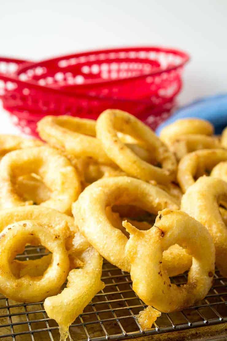 Golden fried onions on a baking rack.