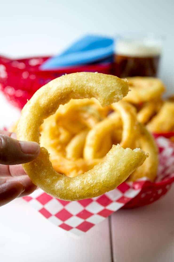 An onion ring with a bite out of the side.