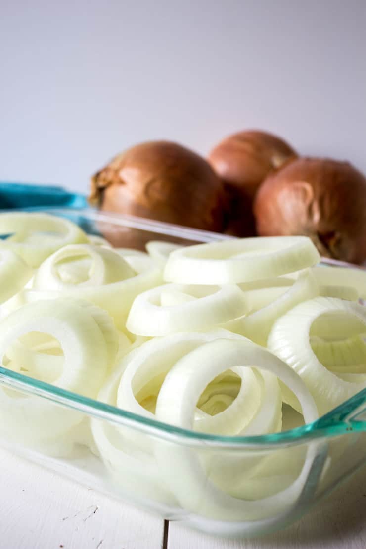 Onions sliced and piled into a baking dish.