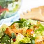 A green salad filled with bell peppers, wonton strips and sprinkled with sesame seeds.
