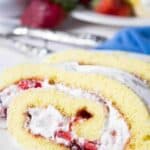 A slice of strawberry roll cake filled with fresh strawberries and whipped cream