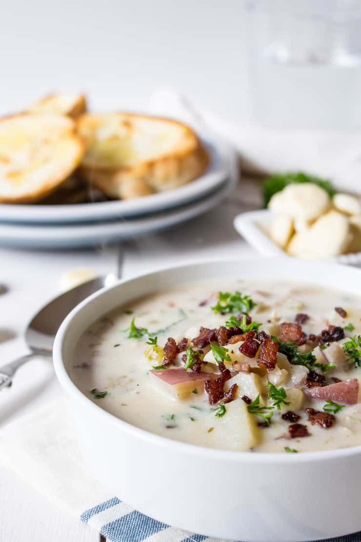 Homemade clam chowder topped with crispy bacon and green chives. 