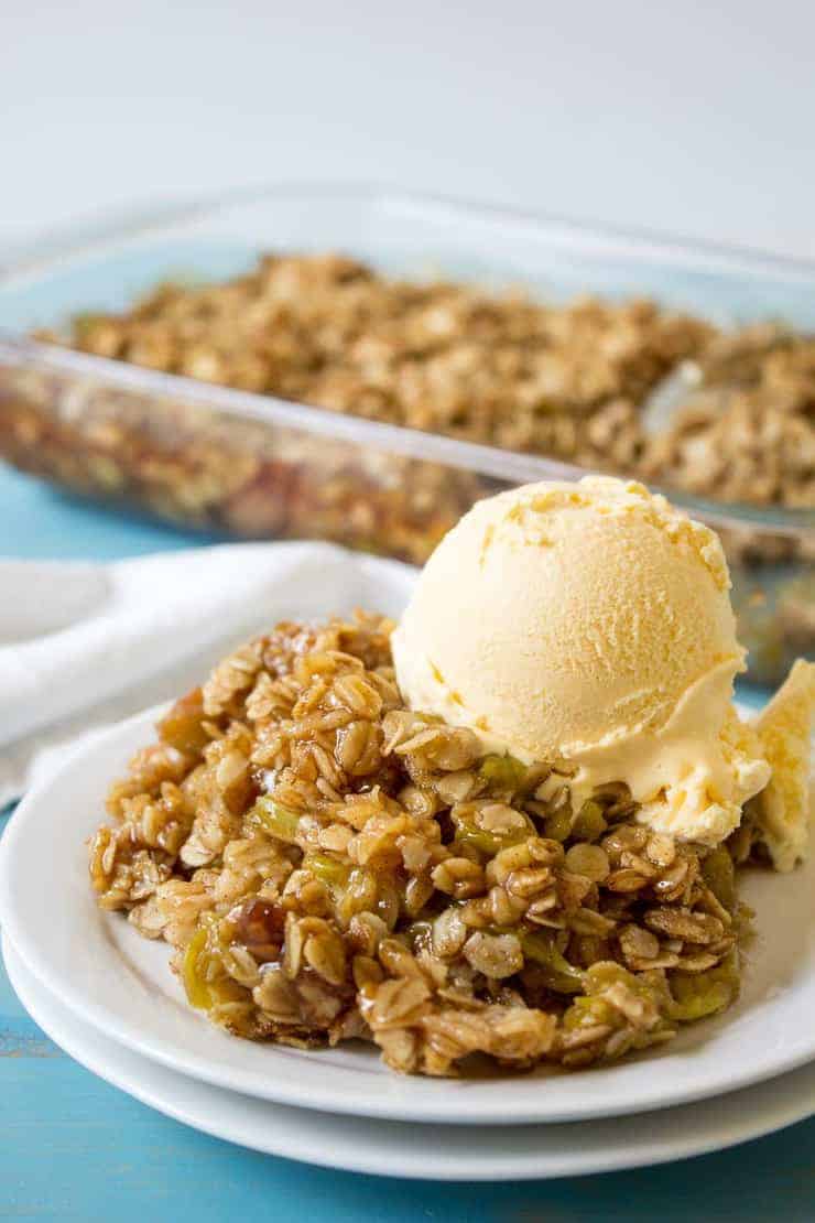 Vanilla ice cream on a scoop of a rhubarb dessert.