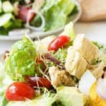 Green lettuce salad with cucumbers, tomatoes, tuna and hard boiled eggs.