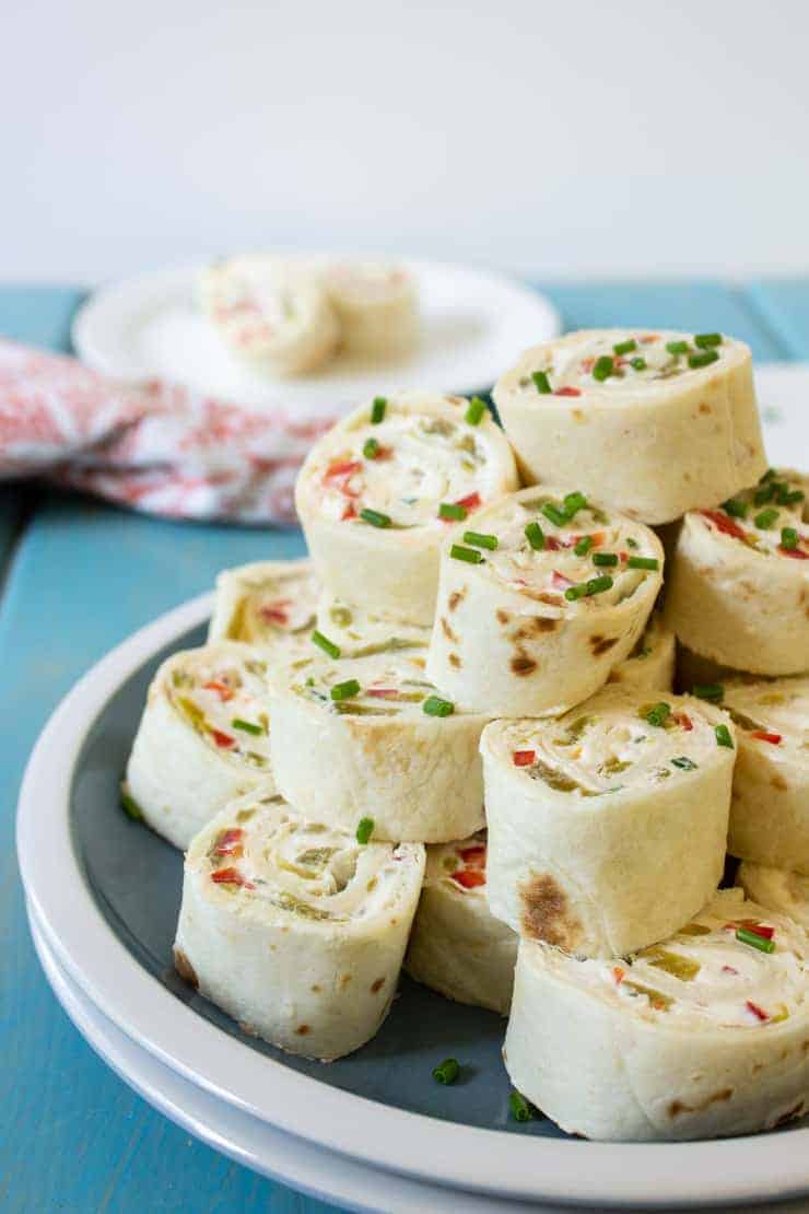 Stack tortilla wraps filled with red peppers and topped with chives.